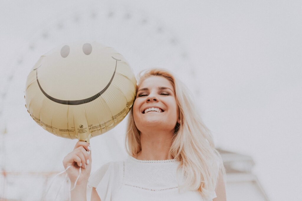 Happy woman with smiley face balloon