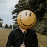 person with smiling balloon